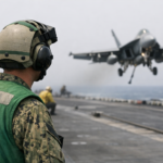 A U.S. Sailor observes flight operations during Operation Epic Fury